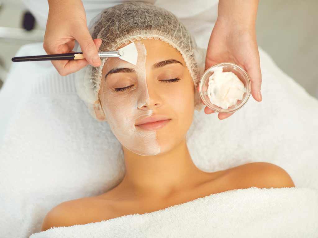 A picture of a woman having a face mask applied to her face. Skincare essentials: Face Mask