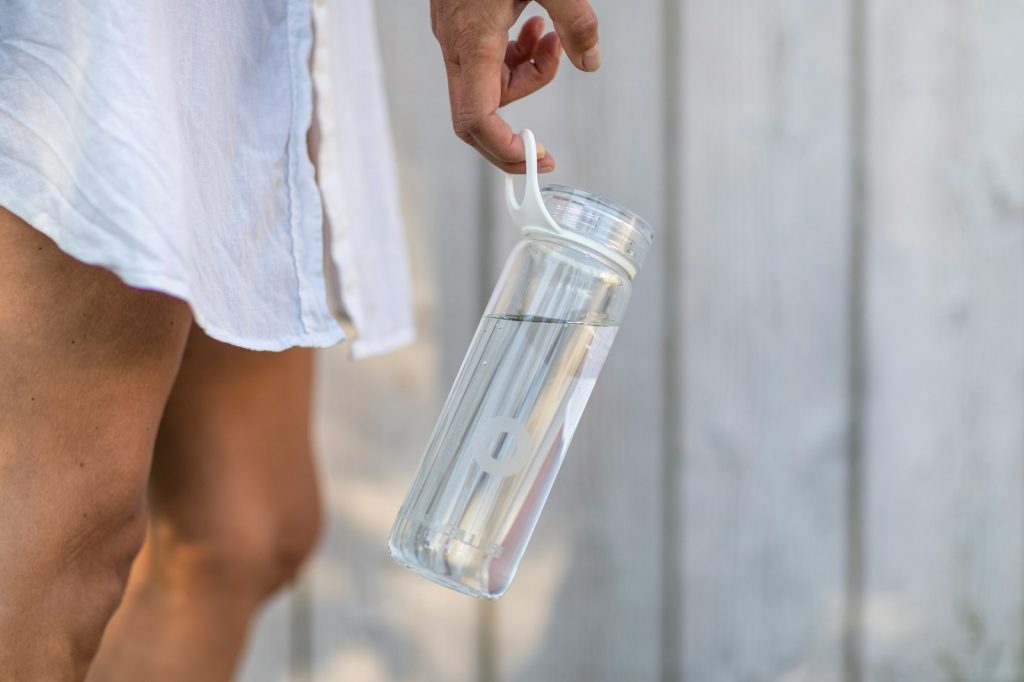 person holding clear glass pitcher